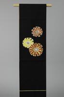 <p>Black Nagoya and maru (double-sided) obi with interwoven white, orange, yellow, silver, and gold stylized daisy&nbsp; motifs.</p>
