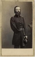 Three-quarter length portrait of a bearded man with one arm in a military uniform. 