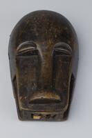 Carved mask with an elongated, protruding nose that extends to the bottom of the mask. The mouth is open with articulated teeth.