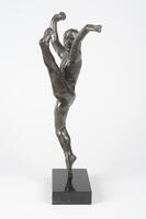 A bronze sculpture of a dancer posed in a high kick.